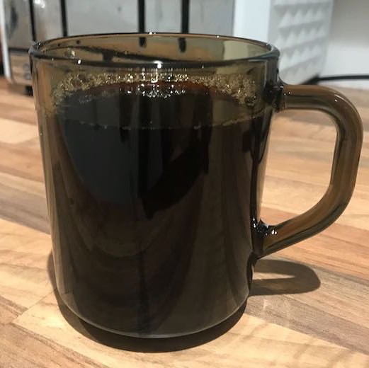 A tan Arcoroc mug filled with coffee. A national treasure of New Zealand