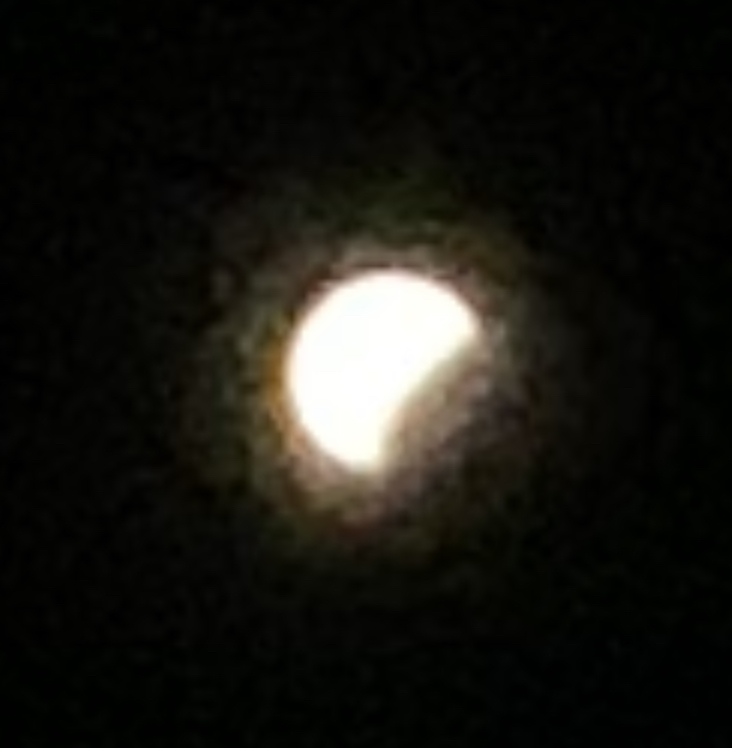 the moon with a circular shadow of the earth partially eclipsing it