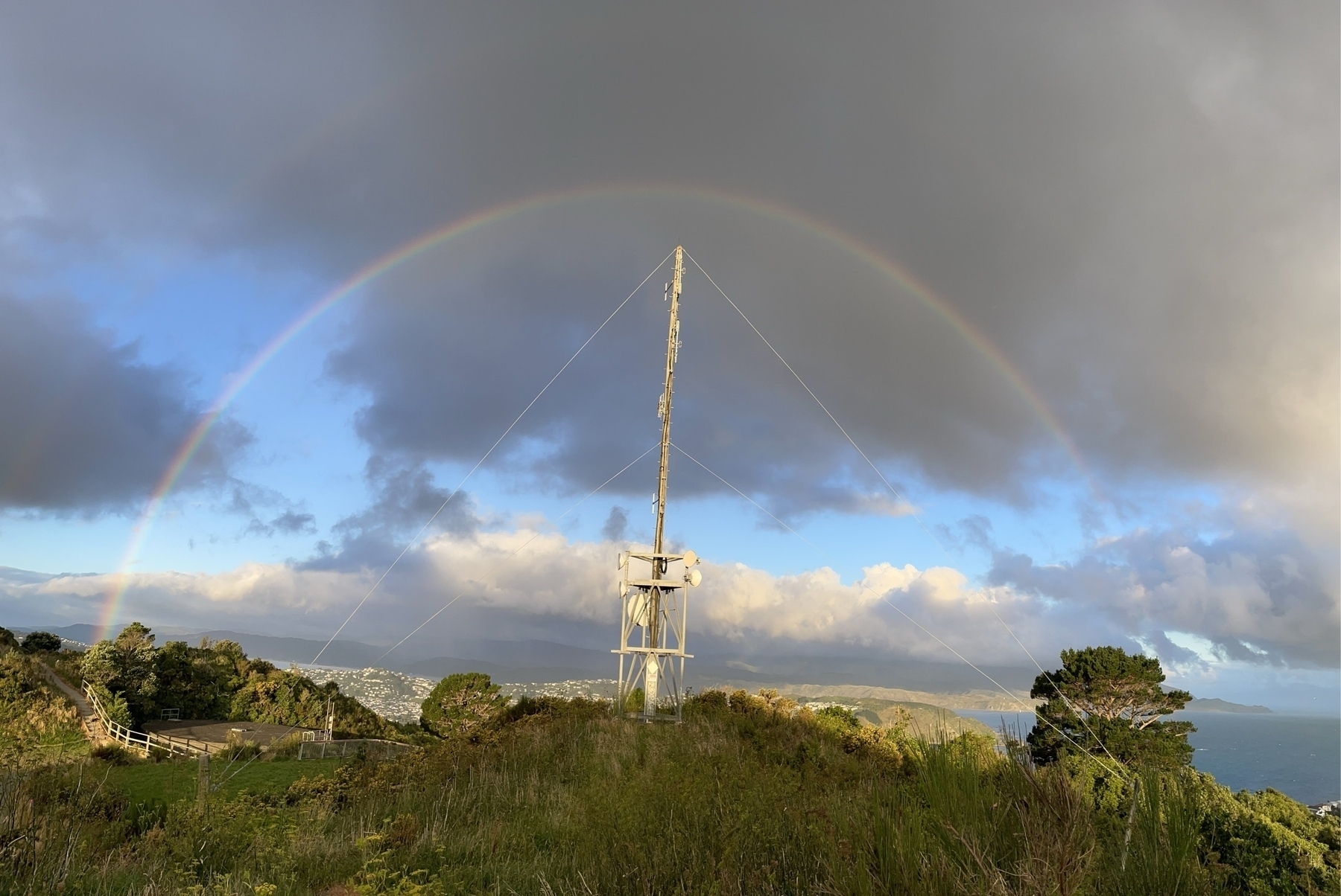 a rainbow with a communication tower in the middle likemhands on a clock
